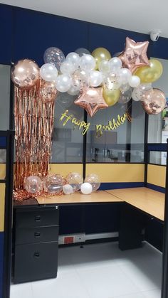 an office cubicle decorated with balloons and streamers