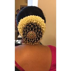 the back of a woman's head wearing a black and yellow hair piece with beads