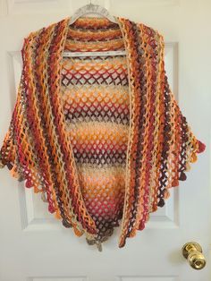 Hand crocheted shawl in V-shape style. Autumn Colors Shawl.  Striped blending of Brown, Tan, Pink and orange.  Drapes well. 64 in. wide from Tip to Tip and 33 in. from nape of neck to to point Acrylic  Machine Wash and Dry  No Iron Brown Crochet Shawl For Fall, Bohemian Crochet Shawl In Acrylic Yarn, Fall Crochet Brown Shawl, Crochet Shawl For Fall, Crochet Shawl For Fall, One Size, One Size Crochet Shawl For Fall, Crochet Yarn Shawl For Fall, Crochet Yarn Shawl, One Size Crochet Yarn Shawl