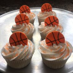 cupcakes with white frosting and orange basketball decorations