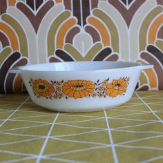 a white bowl with orange flowers painted on it