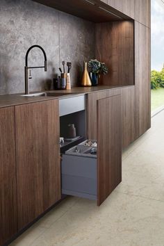 a kitchen with wooden cabinets and an open dishwasher