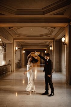 a bride and groom dancing in an elegant hall