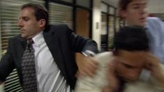 two men in suits and ties are walking down the street