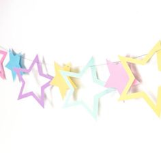 colorful paper stars are hanging on a string