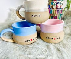 three coffee mugs sitting next to each other on top of a furnishing