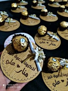 some chocolates are being held by someone's hand with gold foil on them