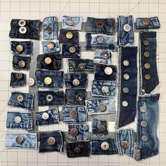 a pile of blue jeans with buttons on them