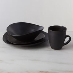 black plates and cups sit on a marble table