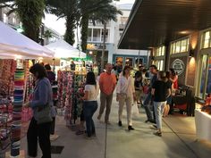 many people are shopping at an outdoor market