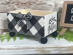 a black and white box with a bow on it next to a chalkboard sign