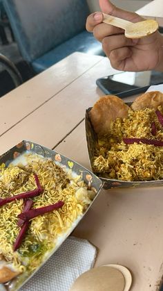 two trays of food sitting on top of a wooden table