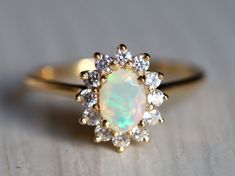 an opal and diamond ring on a table