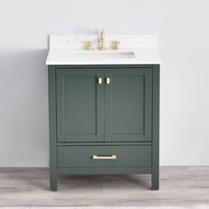 a bathroom vanity with a white sink and green cabinet