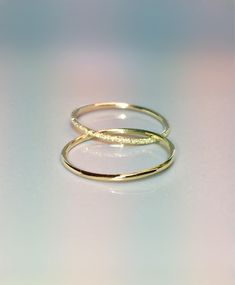 two gold rings sitting on top of each other