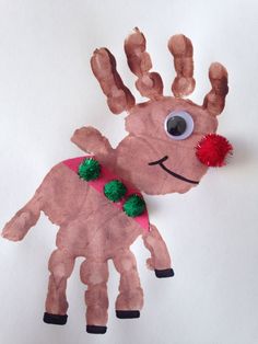 a paper plate with a reindeer made out of it's hands and red pom - poms