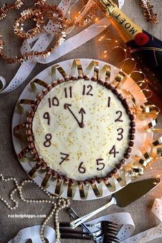 a white cake with gold sprinkles sitting on top of a table covered in confetti