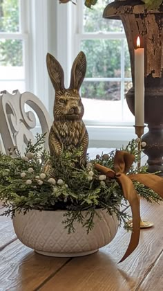 a wooden table topped with a white vase filled with flowers and an animal figurine