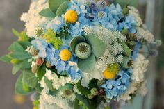 a bridal bouquet with blue flowers and greenery