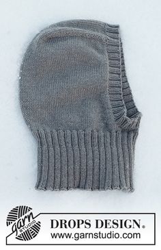 a gray knitted mitten sitting on top of a white surface