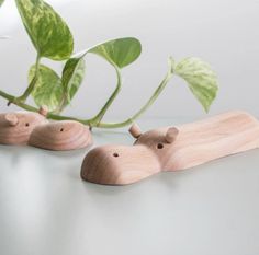 two wooden mice sitting on top of a table next to a green leafy plant