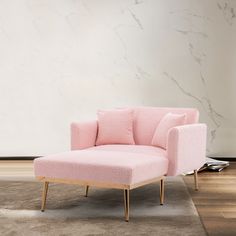 a pink chair sitting on top of a wooden floor next to a white and gray wall