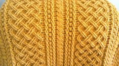 a close up of a yellow knitted sweater