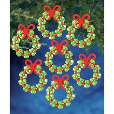 christmas decorations made from beads and bows on a pine tree branch with blue sky in the background