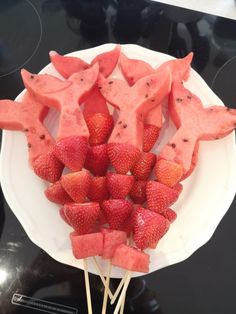 watermelon stars and strawberries on a plate with toothpicks in the shape of animals