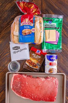 raw meat and ingredients laid out on a baking sheet