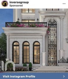 an image of a white building with flowers on the balconies and balcony railings