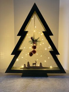 a lighted christmas tree with ornaments and lights in the shape of a triangle on top