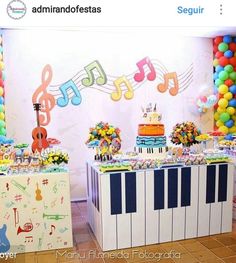 there is a piano and musical notes on the wall behind the cake table at this birthday party