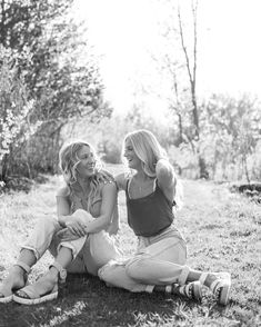 two women sitting on the ground talking to each other