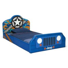 a blue bed with a star on the headboard and an army jeep bed frame