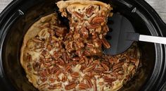 pecan pie in the slow cooker with a spatula scooping into it