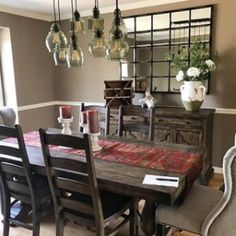 the dining room table is set with six chairs, and there are vases hanging from the ceiling