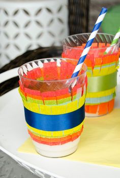 there are two cups with straws in them on the table