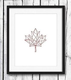 a red maple leaf is shown in a black frame on a white wooden background with the word