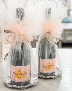 two wine bottles wrapped in tulle and sitting on a table