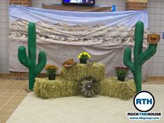 hay bale and cactus decorations in front of a stage