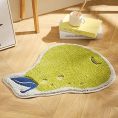 a bathroom rug with an image of a green creature on it and a cup in the corner