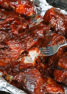 a fork is stuck into some meat on tin foil