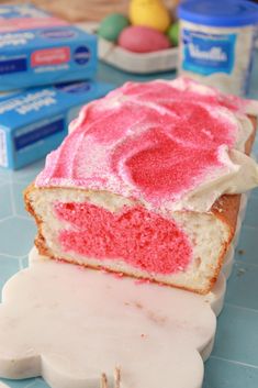 a cake with pink frosting sitting on top of a table