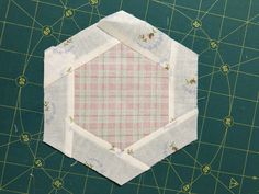 the hexagonal piece is on top of the cutting mat, which has been stitched together