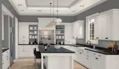 a large kitchen with white cabinets and black counter tops