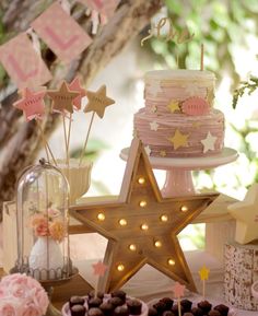 a table topped with lots of cakes and cupcakes next to a star shaped cake