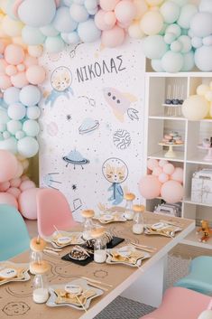 a table set up for a baby's first birthday party with balloons in the background