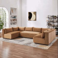 a living room with a large sectional couch in the center and a rug on the floor