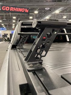 the back end of a pickup truck in a showroom with other vehicles behind it